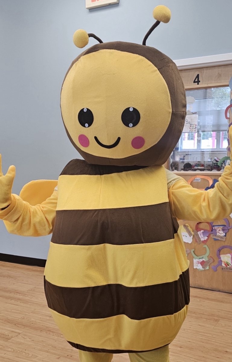 A cheerful bumblebee mascot greeting children